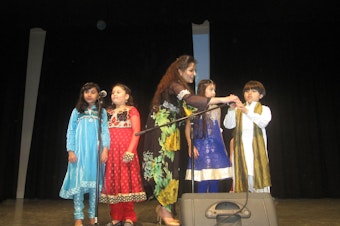 caption: Kiran Shereyar prepares children for their song on Pakistan Day in Redmond