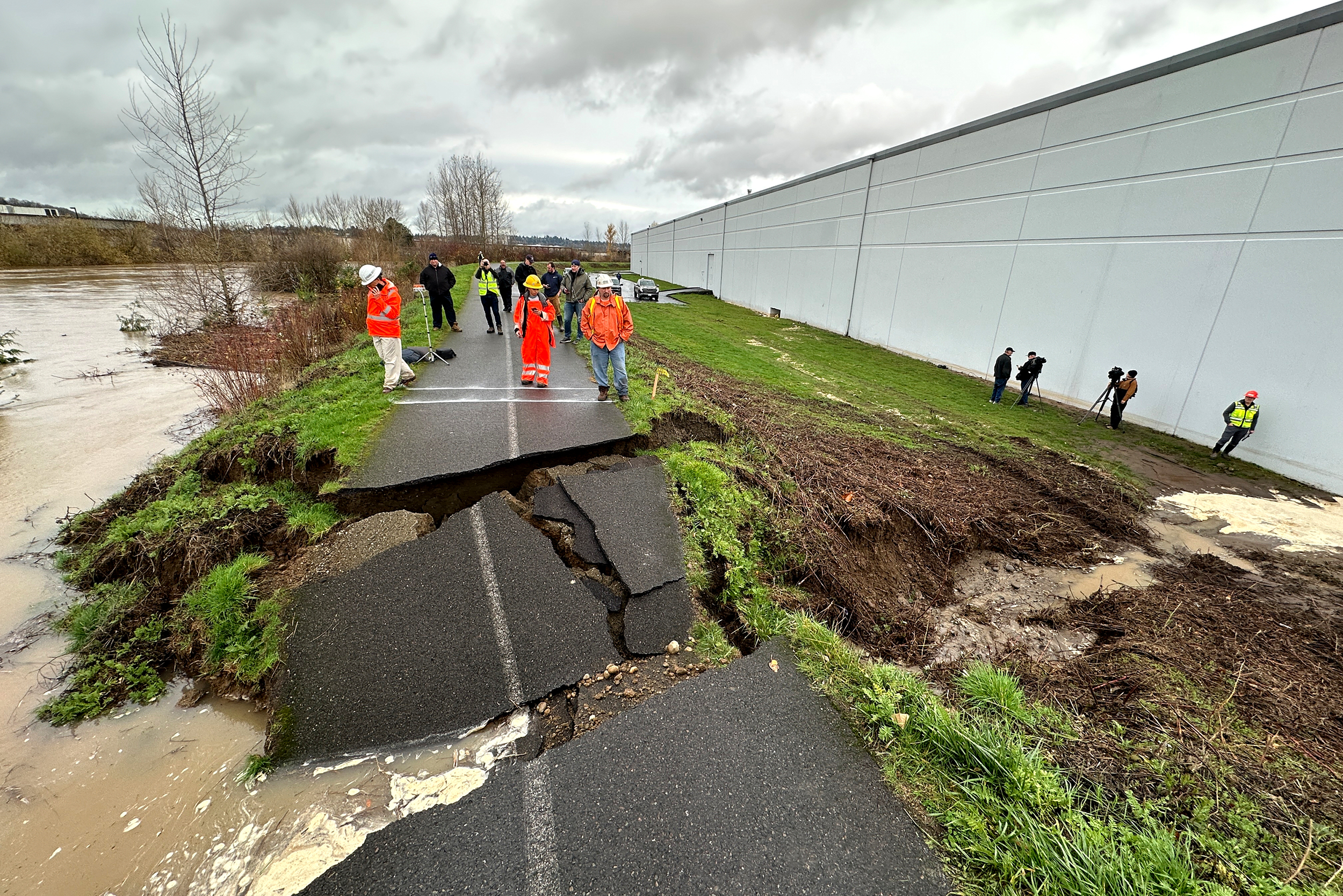 caption: Crews inspect a crack in a levee along the Green River in Tukwila, Wash., Monday, Dec. 15, 2025. 
