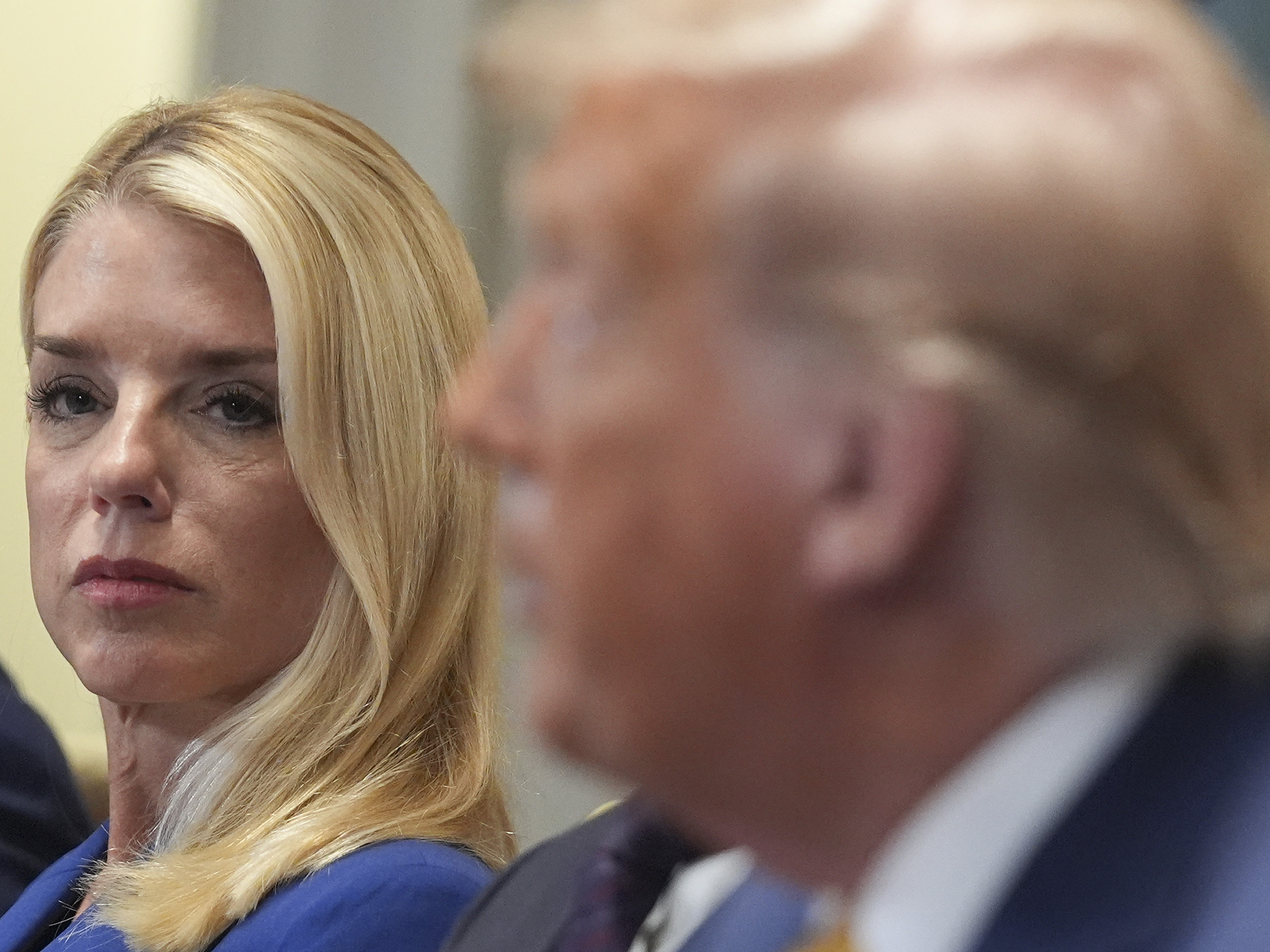 caption: Attorney General Pam Bondi, left, listens as President Donald Trump, right, speaks during a cabinet meeting at the White House.
