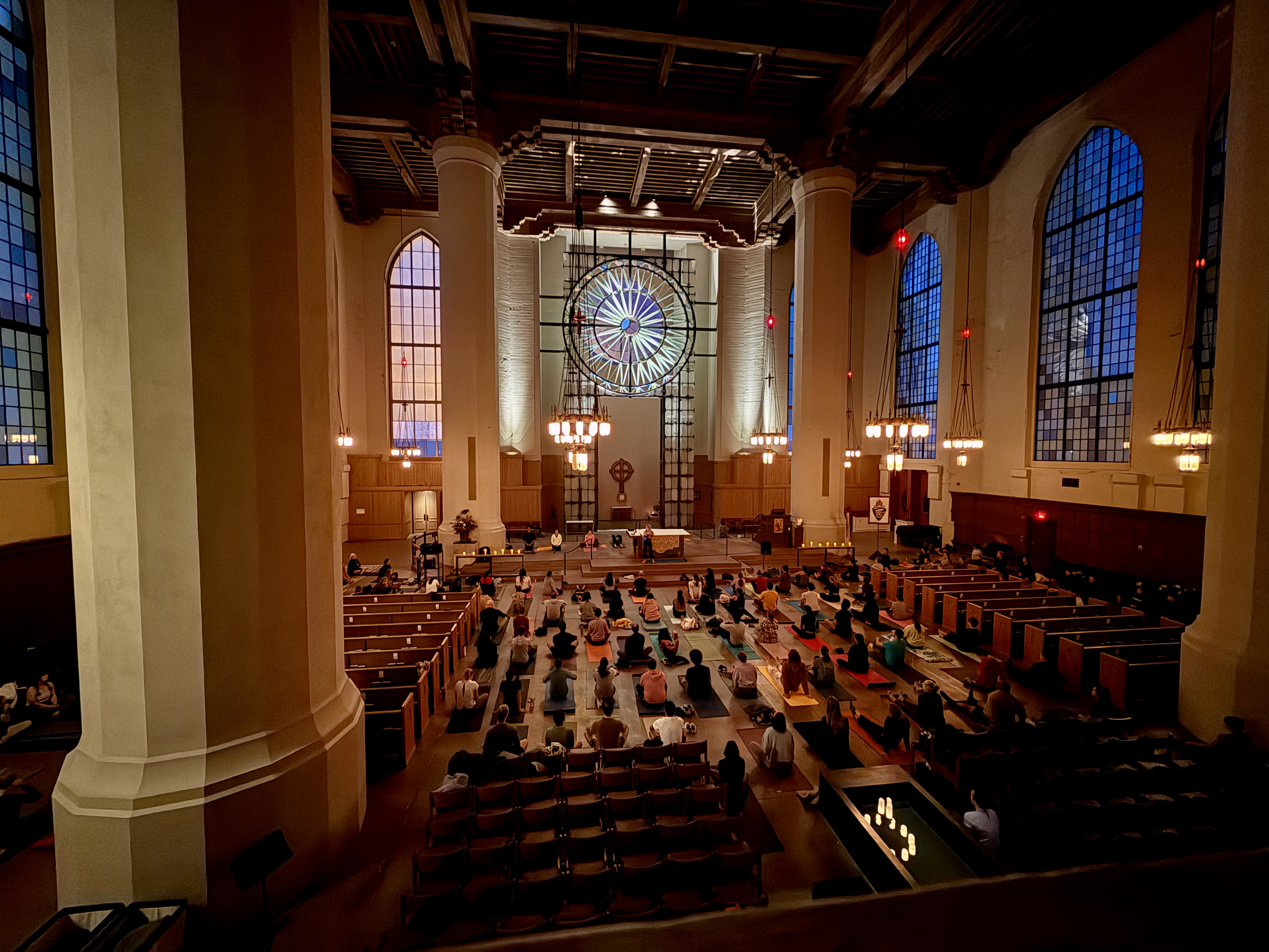 caption: Cathedral yoga goers sit and chat waiting for the start of class at 6:30 p.m. 