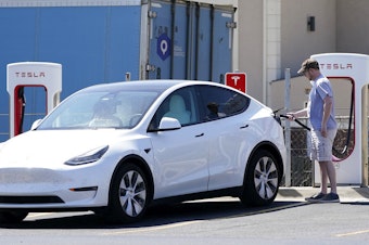 caption: A Tesla owner charges his vehicle in April 2021 at a charging station in Topeka, Kan.. Tesla reported 273 crashes involving partially automated driving systems, according to statistics released by U.S. safety regulators on Wednesday.