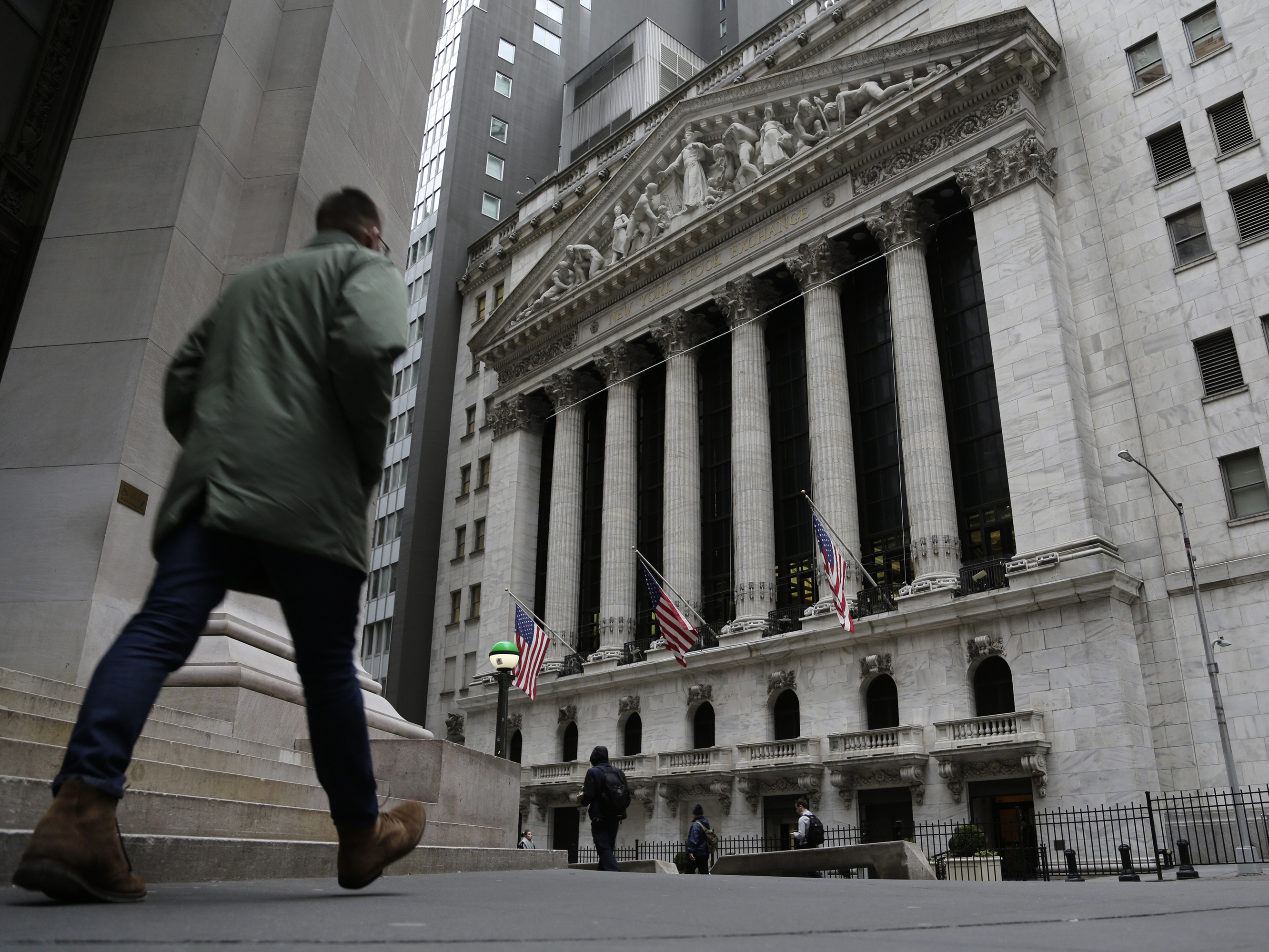 caption: People pass the front of the New York Stock Exchange in New York, on March 22. Brinkmanship in Washington over raising the U.S. debt ceiling has begun to raise worries in parts of the financial markets.