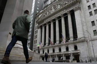 caption: People pass the front of the New York Stock Exchange in New York, on March 22. Brinkmanship in Washington over raising the U.S. debt ceiling has begun to raise worries in parts of the financial markets.
