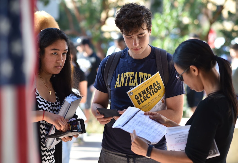 caption: Students wait in line to cast their ballot at a polling station on the campus of the University of California, Irvine, on Nov. 6, 2018.