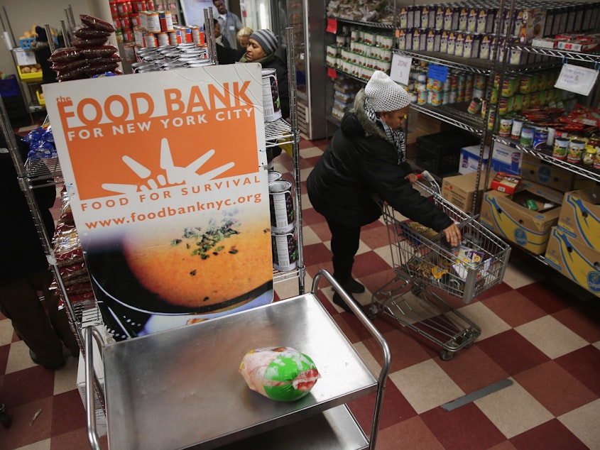 caption: Harlem residents choose free groceries at the Food Bank For New York City in 2013. A number of new rules and actions proposed by the Trump administration could affect poor or low-income people who take advantage of government safety net programs.