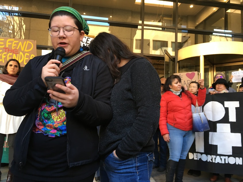 caption: Josefina Mora, left, speaks about her mother's deportation case at news conference in January, 2018 outside the Seattle Immigration Court. Her mother, Maru Mora-Villalpando, buries her head on her shoulder as both women fight back tears.
