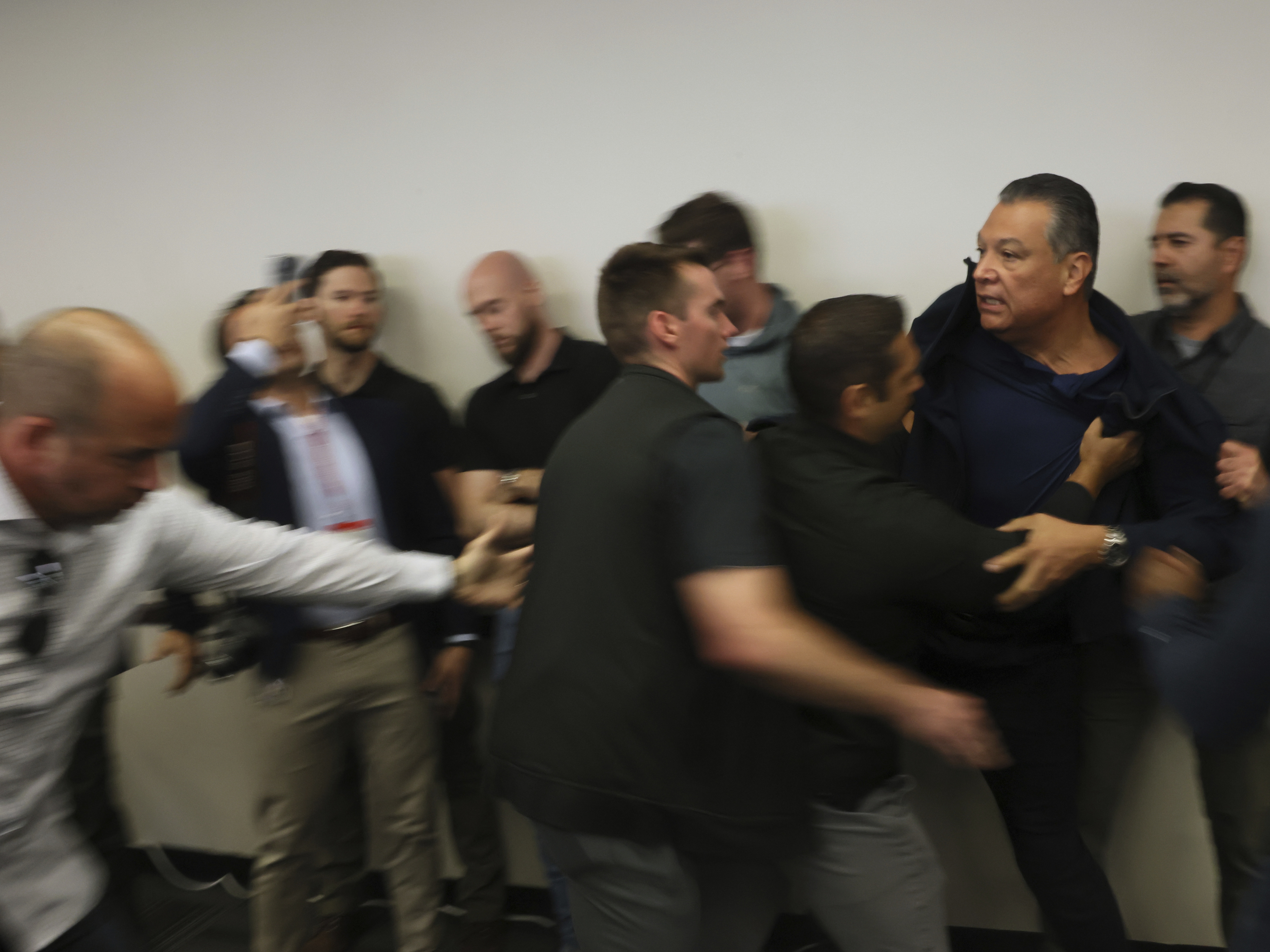 caption: Sen. Alex Padilla, Democrat from California, is removed from the room after interrupting a news conference with Department of Homeland Security Secretary Kristi Noem at the Wilshire Federal Building in Los Angeles on June 12.