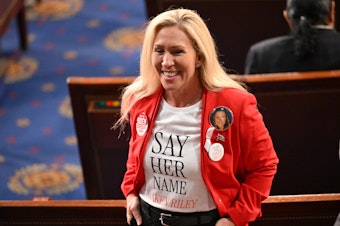 caption: US Representative Marjorie Taylor-Greene (R-GA) wears a shirt and button showing slain Georgia college student Laken Riley ahead of US President Joe Biden's State of the Union address.