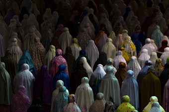 caption: Muslim women praying together in Istiqlal mosque, Jakarta, Indonesia.