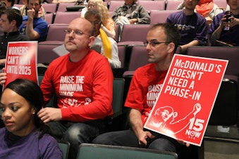 caption: Community members attend a public hearing about raising the minimum wage in Seattle.