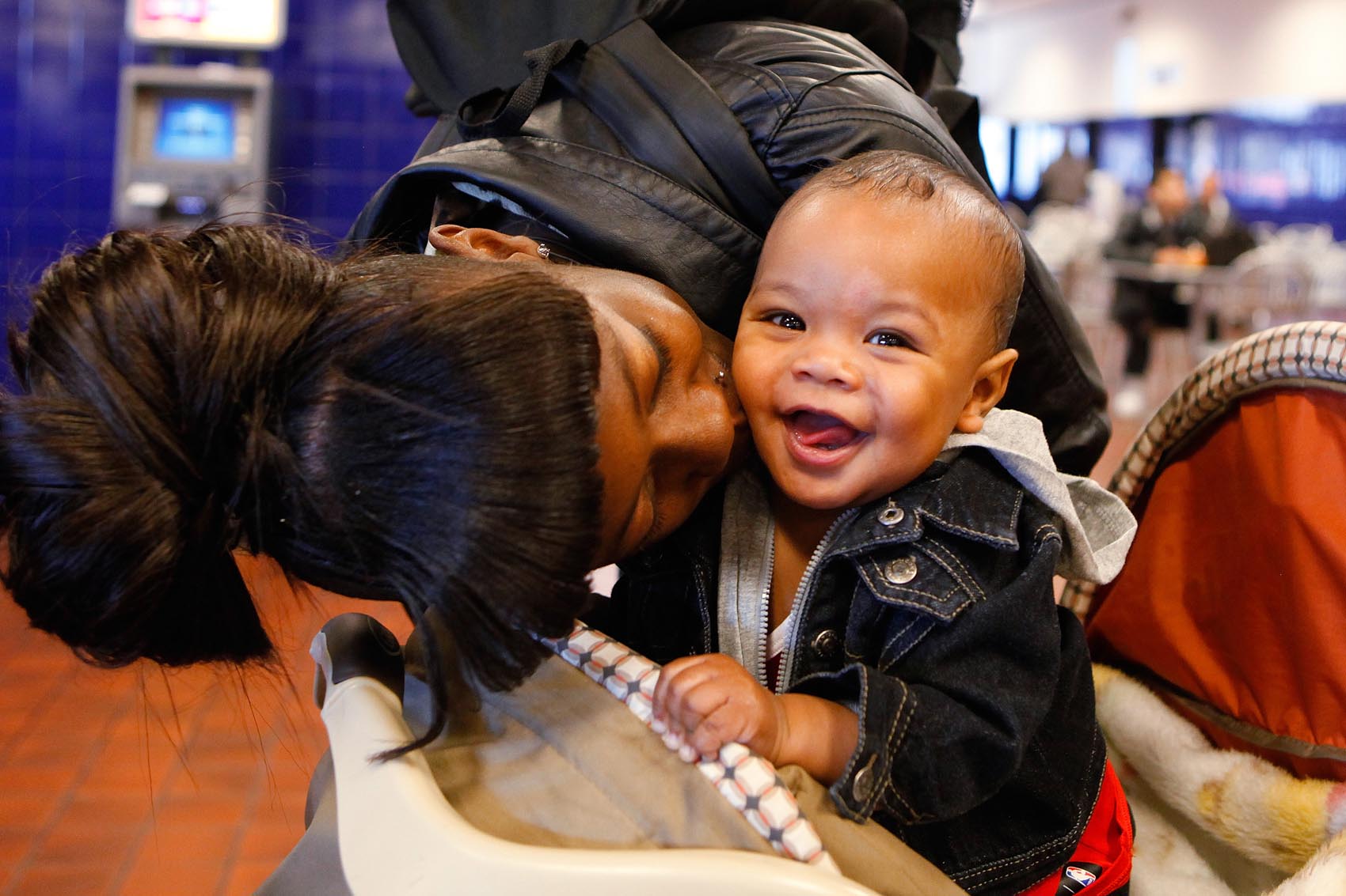 caption: Asia Daniels gives her six-month-old son Quincy a kiss as they wait to board a bus at the Greyhound Bus Terminal  in Denver on Wednesday, Nov. 21, 2012. They were on their way to Colorado Springs, Colo., to spend Thanksgiving with family. (Ed Andrieski/AP)
