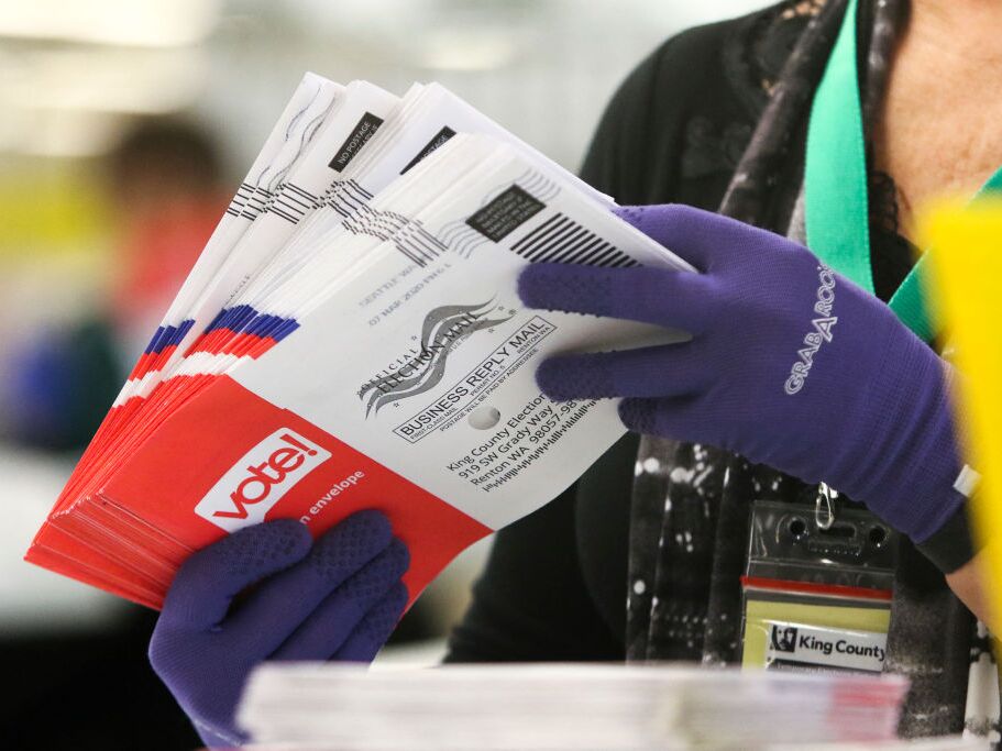 caption: An election worker sorts vote-by-mail ballots for the presidential primary at King County Elections in Renton, Wash., in March 2020.