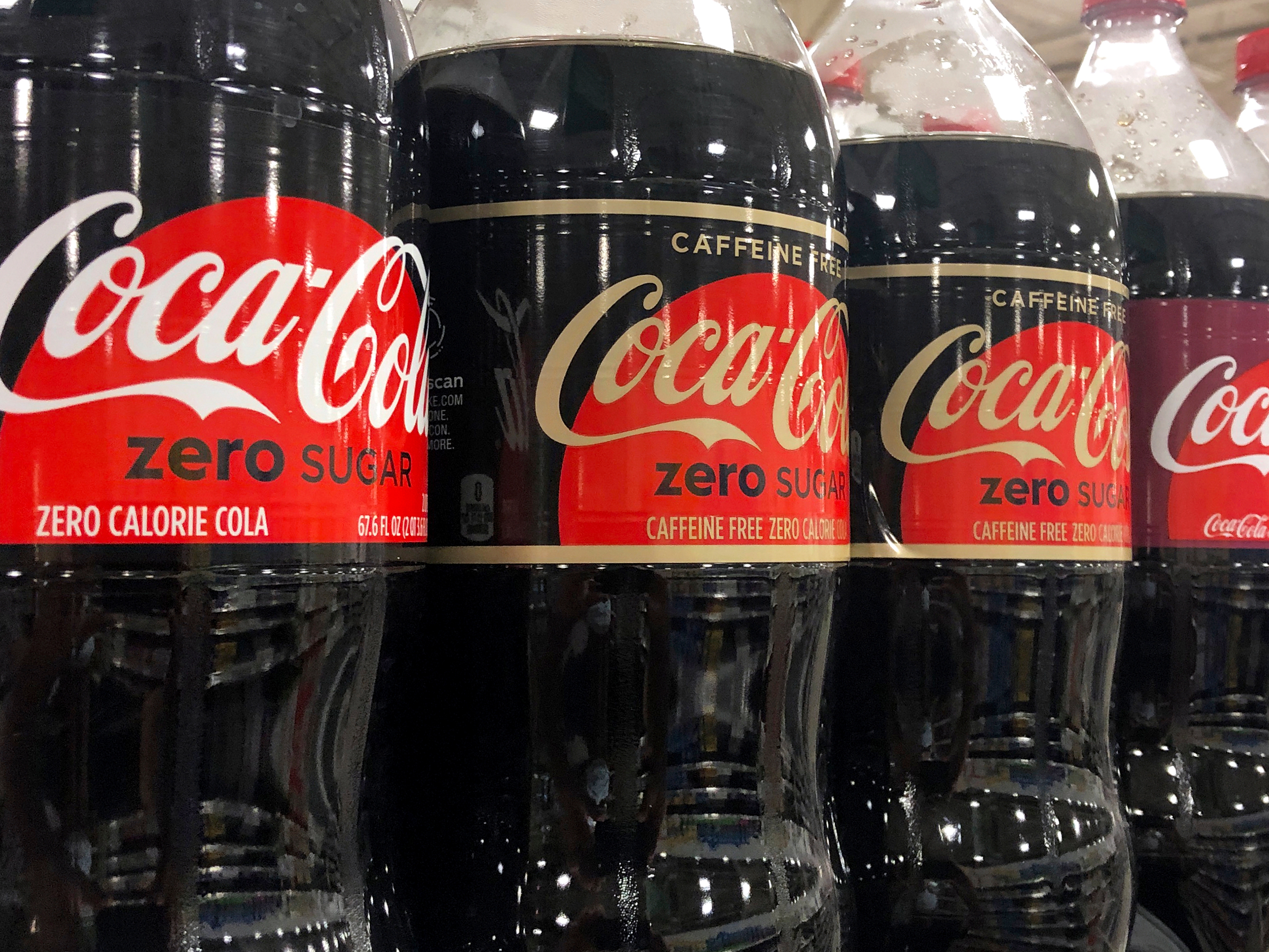 caption: Bottles of Coca-Cola products sit on a shelf at a store in Dania Beach, Fla., Oct. 20, 2020.