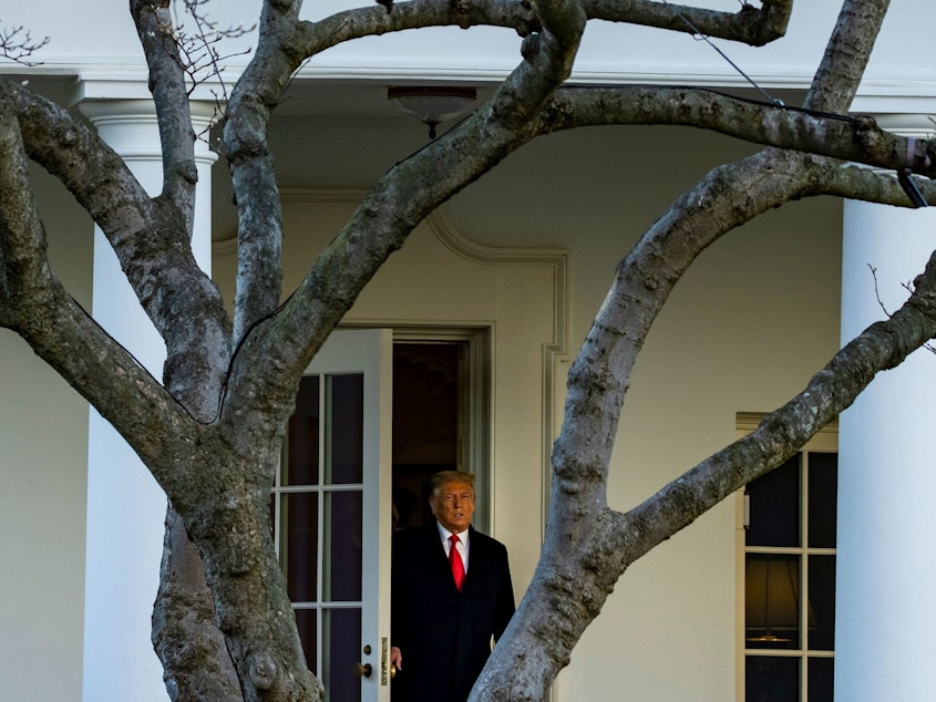 caption: President Trump emerges from the Oval Office on Wednesday as he departs the White House en route to Florida's Mar-a-Lago, where he will spend Christmas and New Year's Eve.