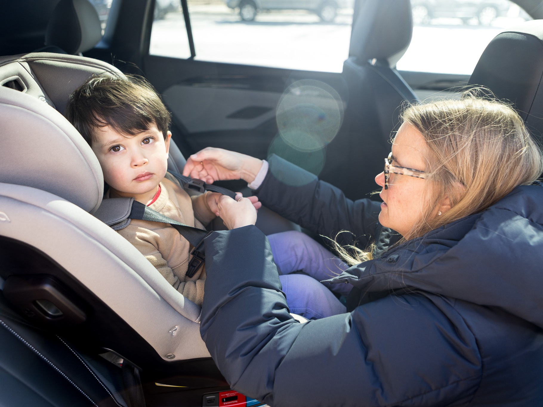 caption: Elizabeth Kanagawa, a certified child passenger safety technician, demonstrates how to adjust the harness of a car seat. She is also the owner of Three Littles, a children's store that sells car seats and strollers, among other items, in Washington, D.C.