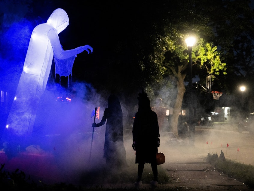 caption: Children walk past Halloween decorations last year. In several U.S. towns, it's illegal for kids over 12 years old to go trick-or-treating.