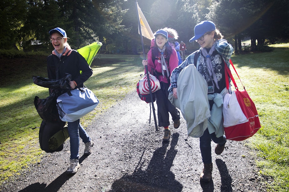 caption: From left, Zephyra Bingham, 14, Ariana Spradlin, 13, and Rachel Becking, 13, carry their belongings before setting up their tents during the Boy Scouts of America Bootcamp for girls on Saturday, October 6, 2018, at Camp Thunderbird in Olympia. 