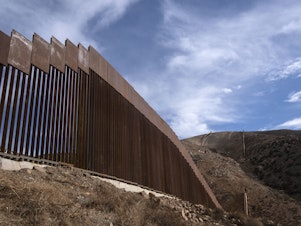 caption: A reinforced section of the U.S.-Mexico border fencing seen in eastern Tijuana, Baja California, Mexico on Jan. 20. President Biden signed an executive action and has halted construction of the massive wall for 60 days.