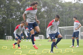 caption: DeAndre Yedlin (third from left) trains with the US National Team at the 2014 World Cup in Brazil.