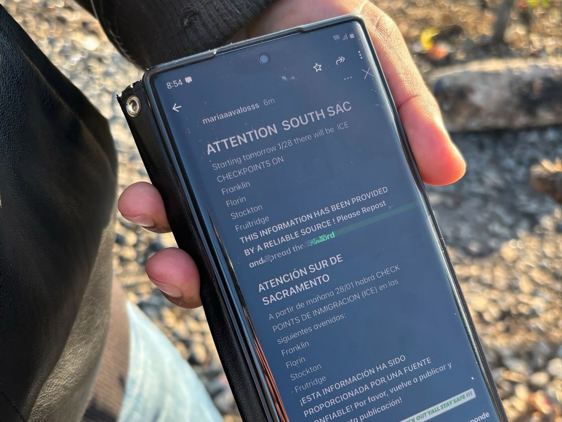 caption: Mario, who is in the U.S. without legal status, shows a social media hoax he saw on his phone warning of immigration checkpoints in Sacramento, Calif.