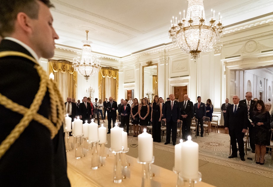 caption: President Donald Trump and First Lady Melania Trump join guests in singing "America the Beautiful" during a reception in honor of Gold Star Families on Sept. 27, in the East Room of the White House. On Thursday, Trump suggested he may have contracted COVID-19 from one of the family members at the event.