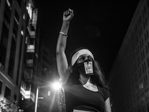 caption: Ethiopia Berta, an activist and educator who has been fighting for a change for many years, marches in Washington, D.C., on June 6. Last year she worked to keep Democracy Prep Public Charter School in southeast Washington, D.C., from closing.