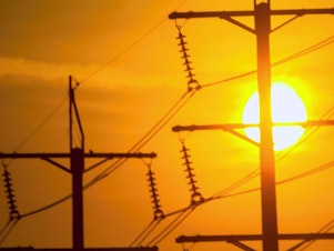 caption: Powerlines stand in the setting sun.