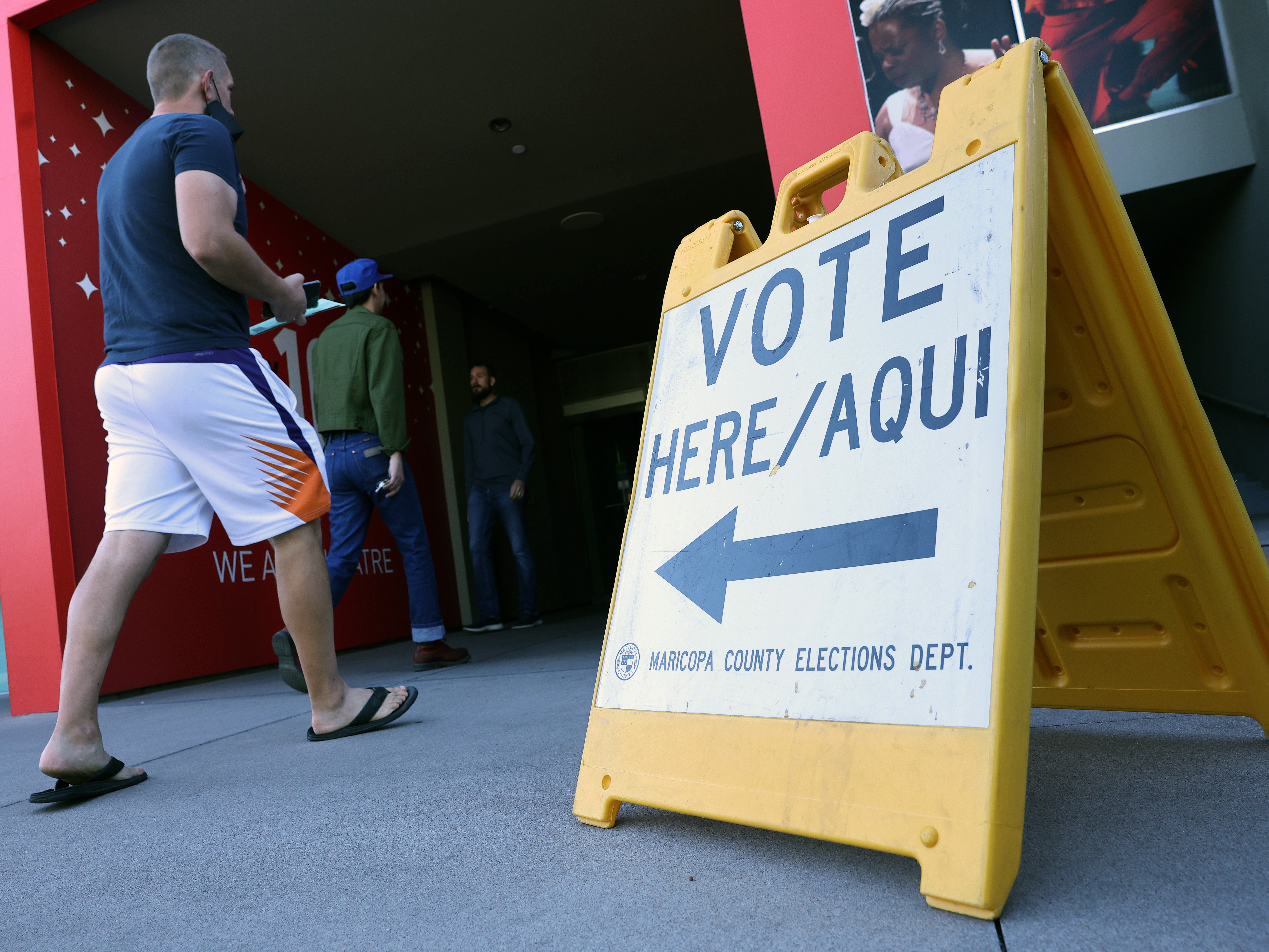caption: Voters head to a polling place in November 2022. Outside money is pouring into a Phoenix-area congressional district in a heated Democratic primary on Tuesday.
