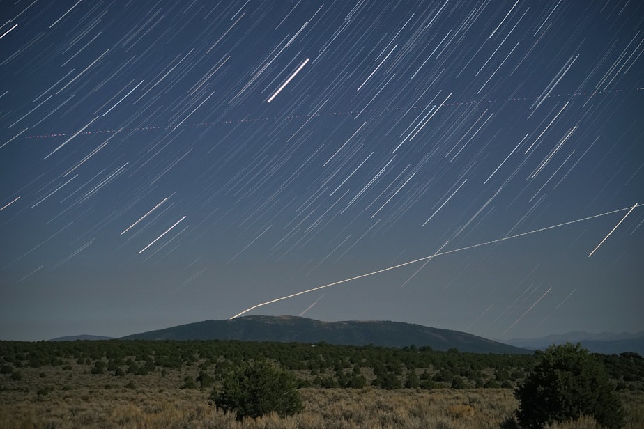 caption: Night over Taos, NM, featuring an unexplained light in the sky.