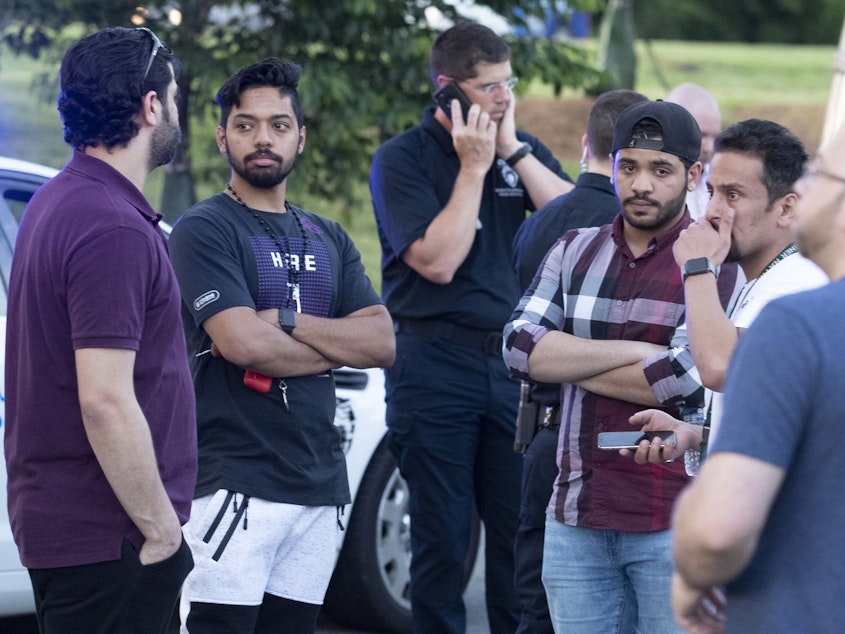 caption: People gather across from the campus of the University of North Carolina, Charlotte after a shooting at the school on Tuesday.