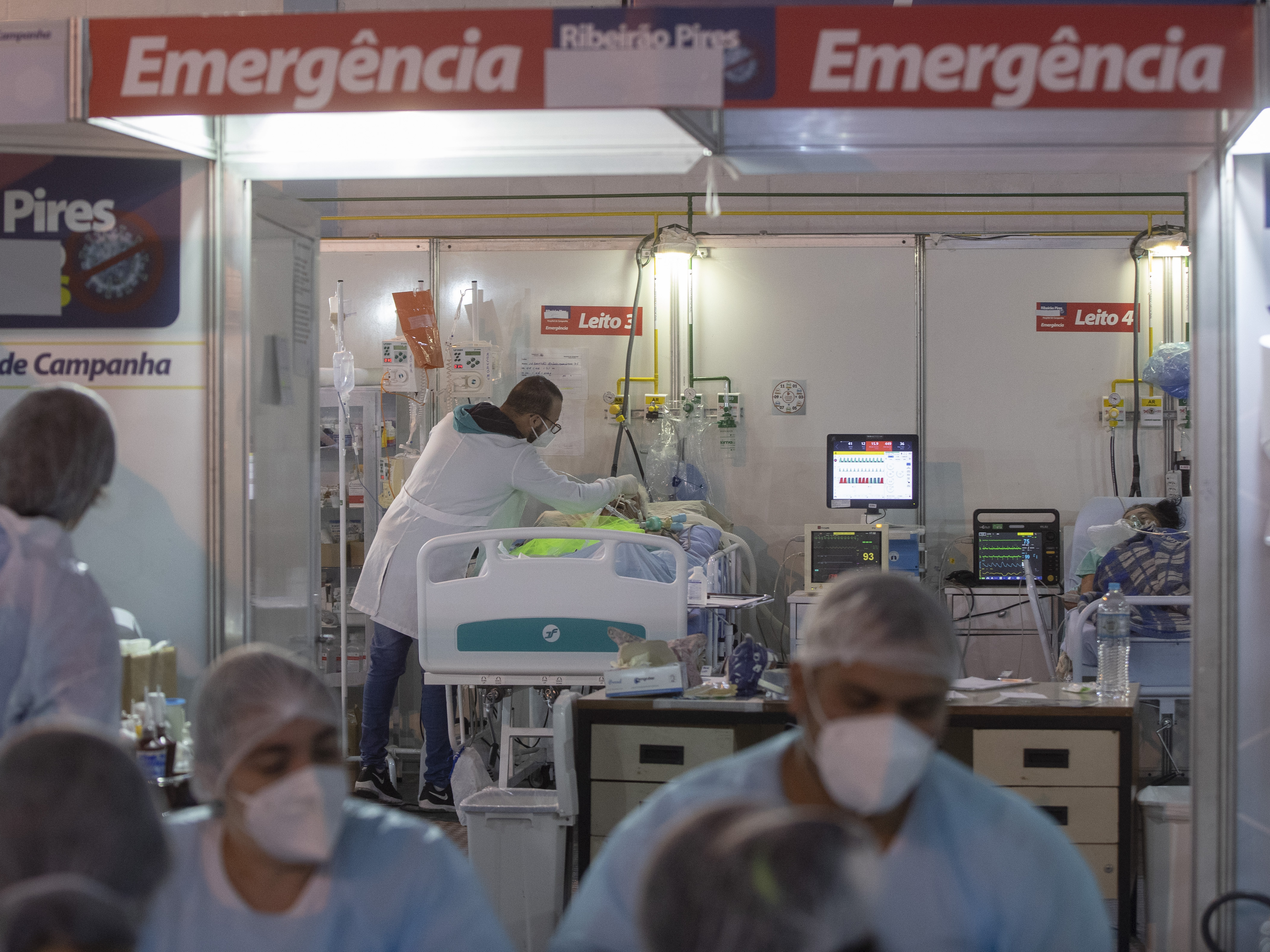 caption: A health worker treats a COVID-19 patient at a field hospital in Ribeirao Pires, greater Sao Paulo area, on Tuesday.