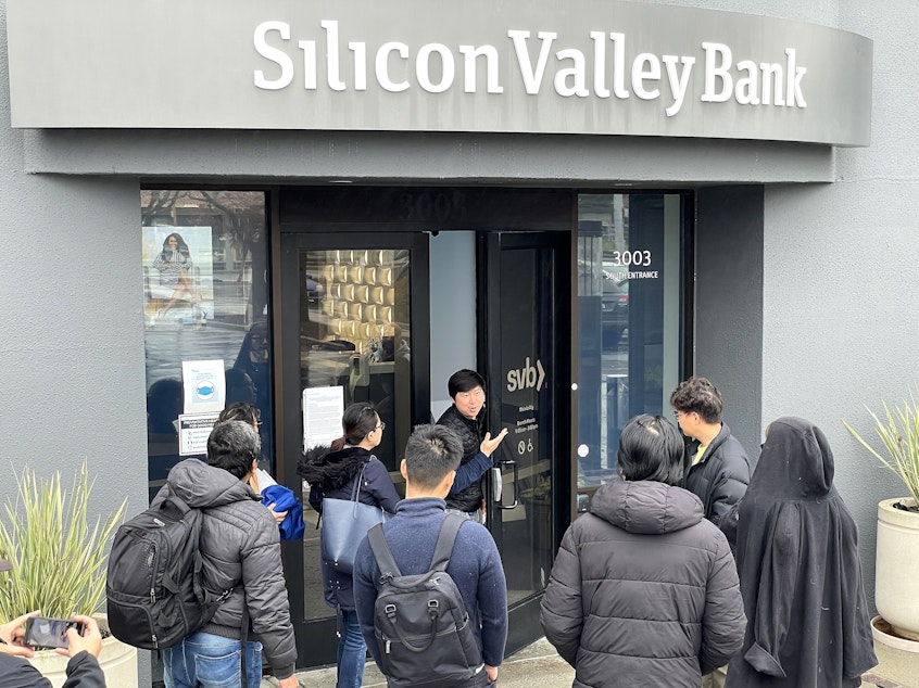 caption: SANTA CLARA, CALIFORNIA - MARCH 10: A worker (C) tells people that the Silicon Valley Bank (SVB) headquarters is closed on March 10, 2023 in Santa Clara, California.