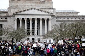 caption: The Washington state Senate passed a bill on Wednesday that would remove the personal belief exemption from the required vaccinations for measles, mumps and rubella. Here, people protest the related house bill outside Washington's Legislative Building in Olympia in February.