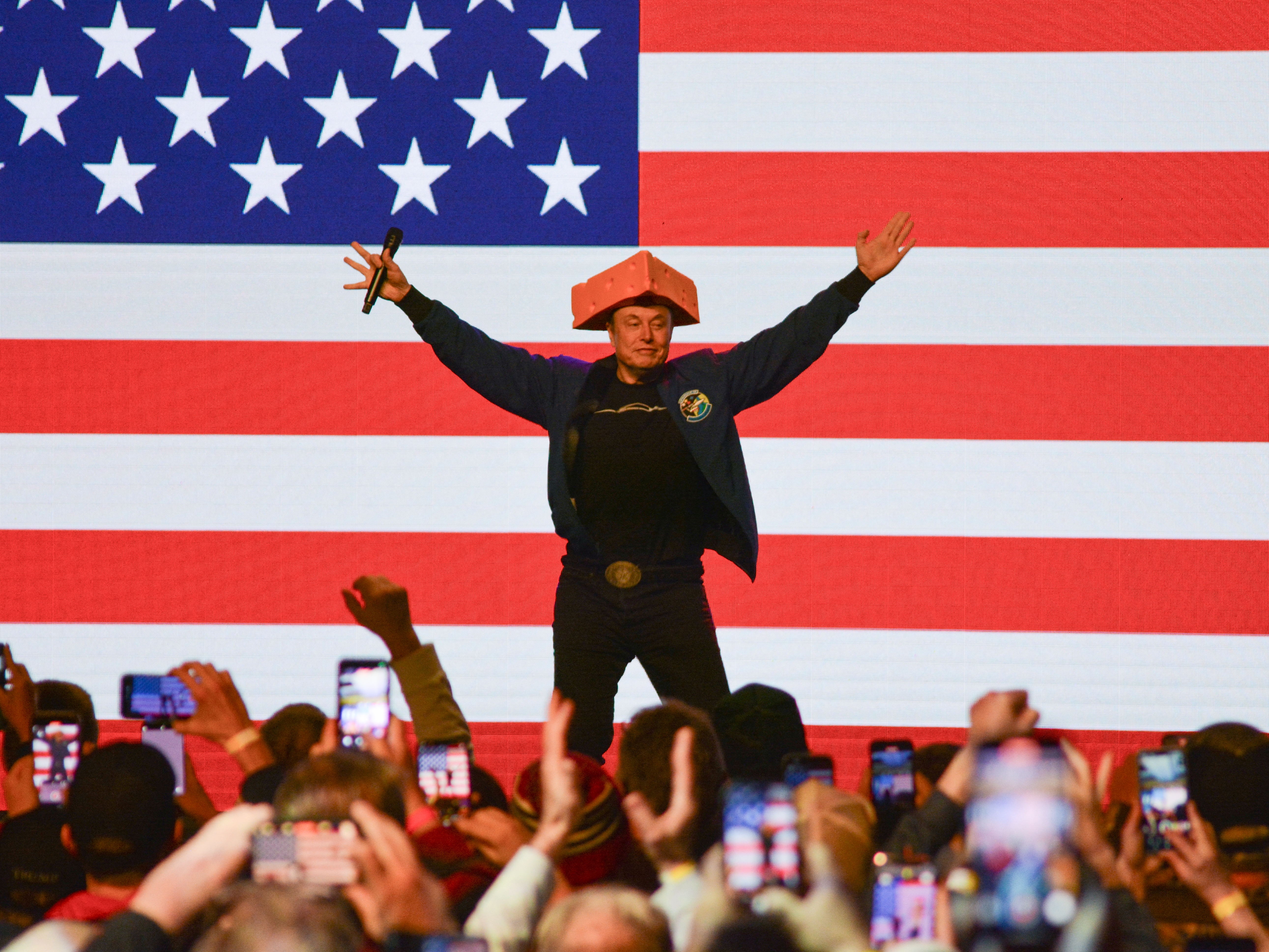 caption: Elon Musk wears a cheesehead hat as he speaks during a rally in Green Bay, Wisc. on March 30, 2025. An election to choose a new state Supreme Court justice takes place Tuesday and Musk has contributed millions to the race, hoping to secure a win for the conservative candidate.