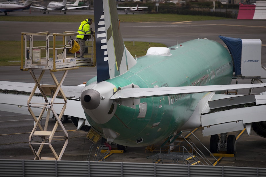 caption: A Boeing employee works on a 737 MAX on Monday, December 16, 2019, in Renton.