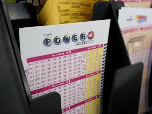 caption: Blank forms for the Powerball lottery sit in a bin at a grocery store, in Des Moines, Iowa, on Jan. 12, 2021.