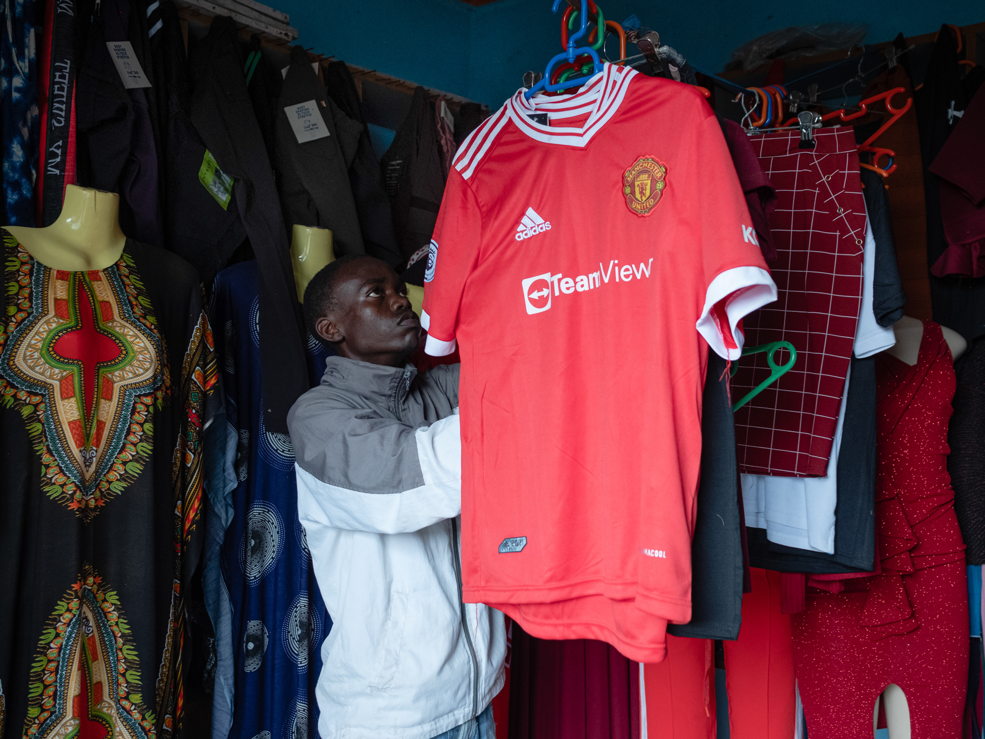caption: Joel Joseph in the clothing shop where he worked with a friend during the pandemic.
