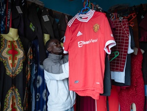 caption: Joel Joseph in the clothing shop where he worked with a friend during the pandemic.