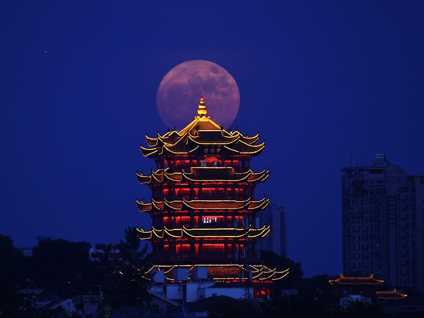 caption: A supermoon is pictured near the Yellow Crane Tower in Wuhan, central China's Hubei Province, July 13, 2022.