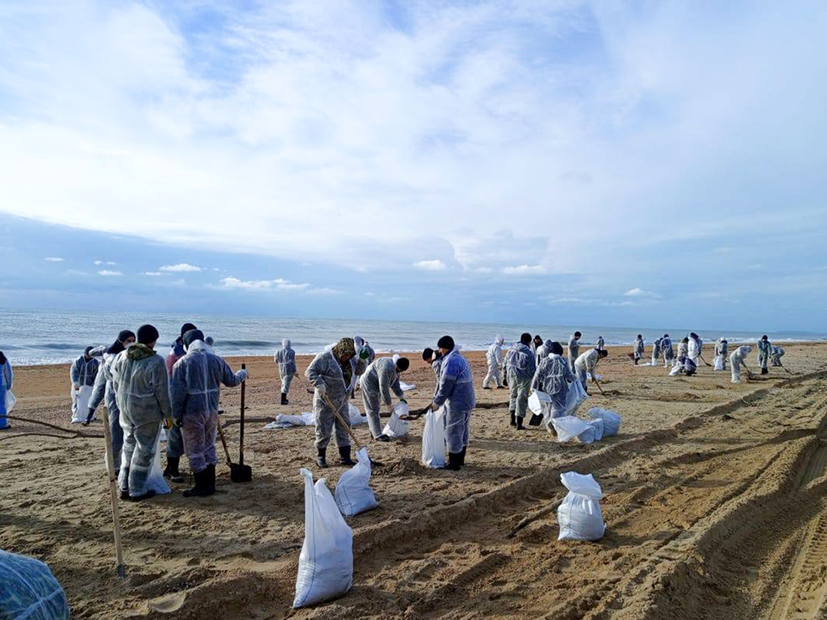 caption: Rescuers and volunteers work to clean up tons of fuel oil that spilled out of two storm-stricken tankers more than two weeks ago in the Kerch Strait, near Anapa in Russia's southern Krasnodar region.