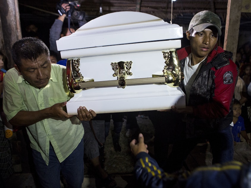 caption: Neighbors carry the coffin that contains the remains of 7-year-old Jakelin Caal Maquin into her grandparents' home in San Antonio Secortez, Guatemala. The 7-year-old girl died while in the custody of the U.S. Border Patrol.