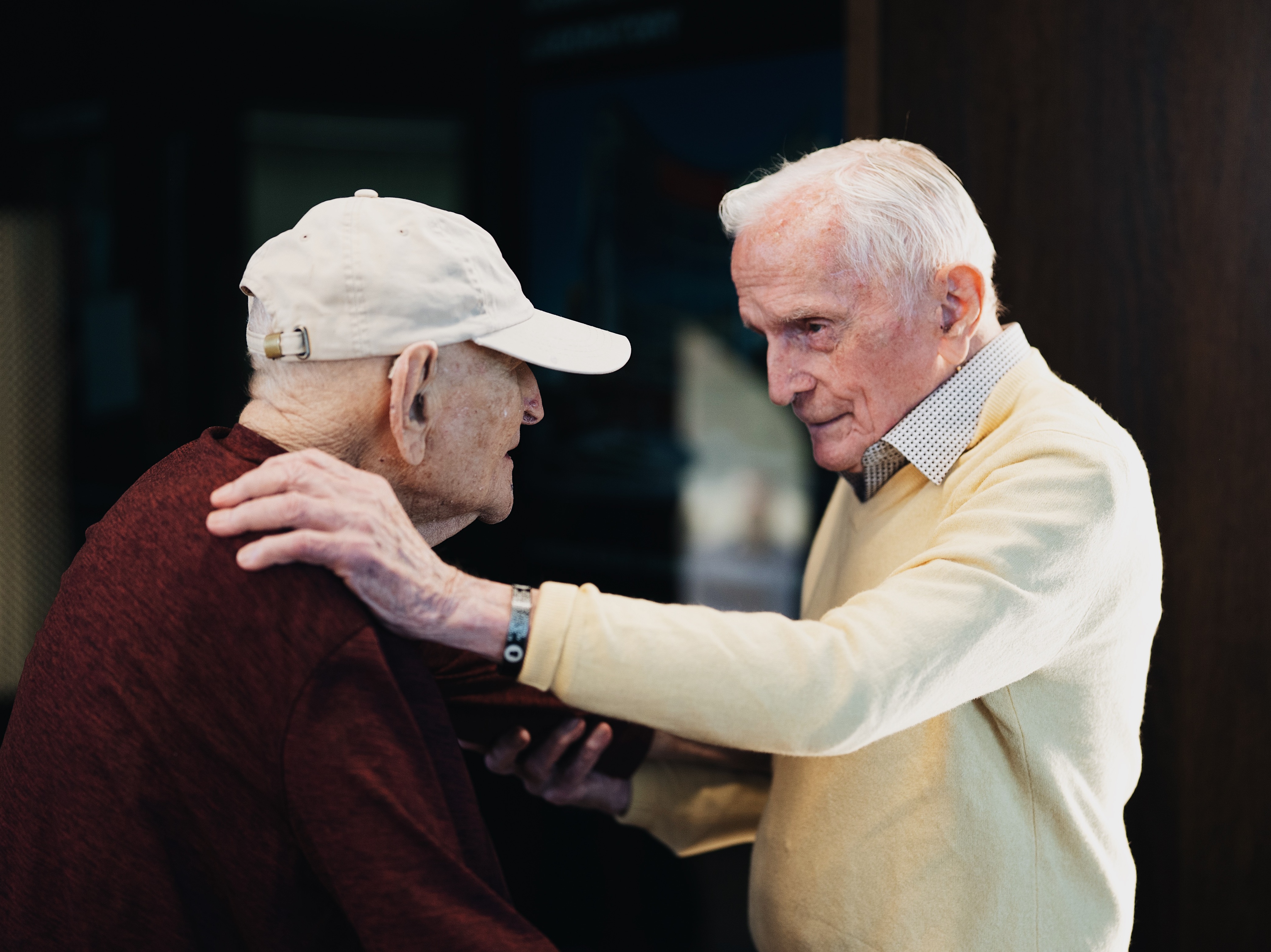 caption: Andrew Roth (left) stands up from his wheelchair to give Jack Moran a hug at the Shoah Foundation at the University of Southern California in Los Angeles. Roth was imprisoned in the Buchenwald concentration camp, which Moran helped liberate while serving in the U.S. Army.<br><br><br><br>