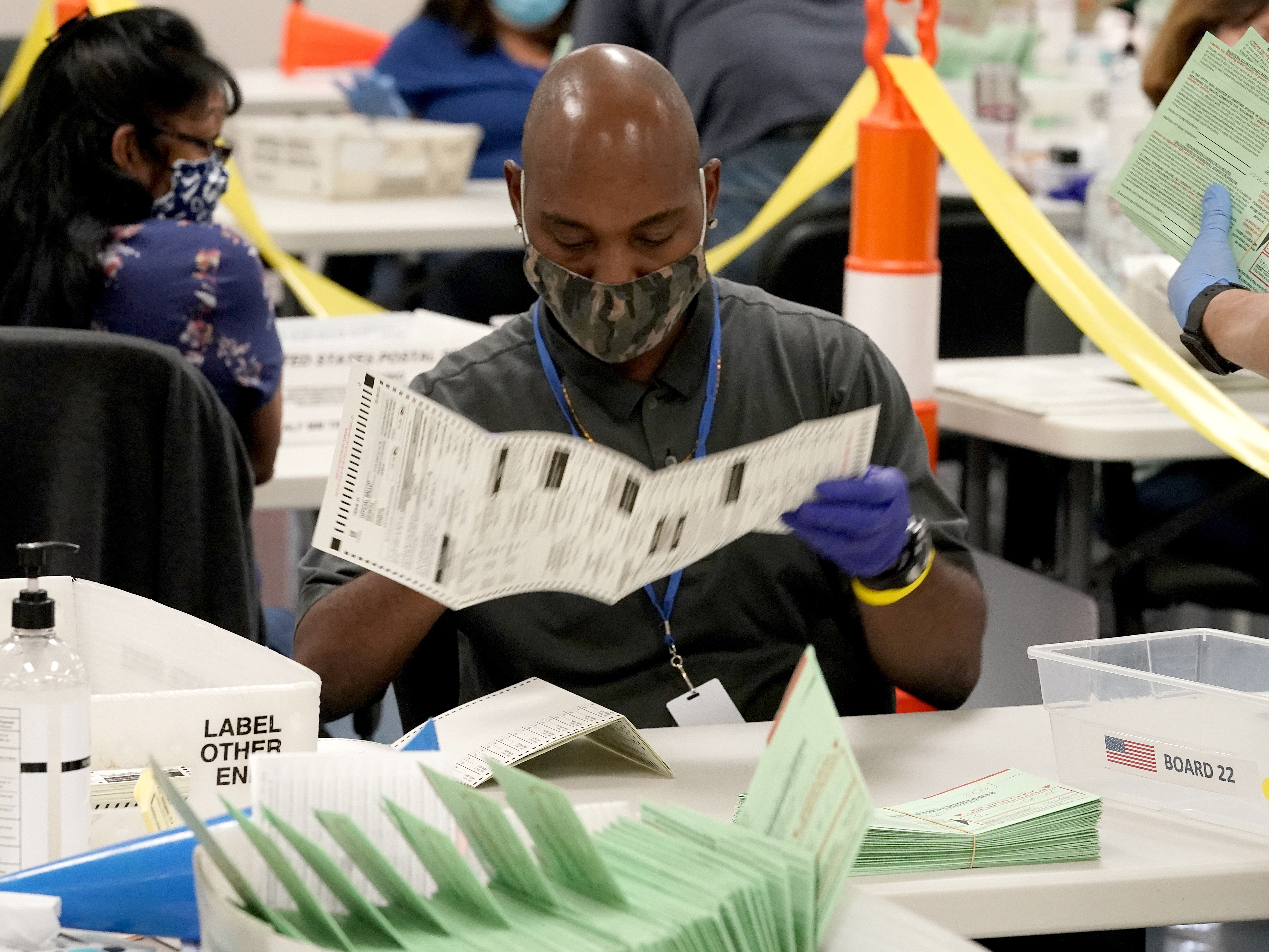 caption: Election workers sort ballots at the Maricopa County Recorder's Office in Phoenix. Mail-in ballots in Arizona are already being counted.