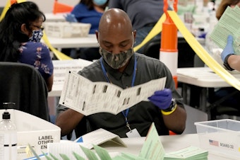 caption: Election workers sort ballots at the Maricopa County Recorder's Office in Phoenix. Mail-in ballots in Arizona are already being counted.