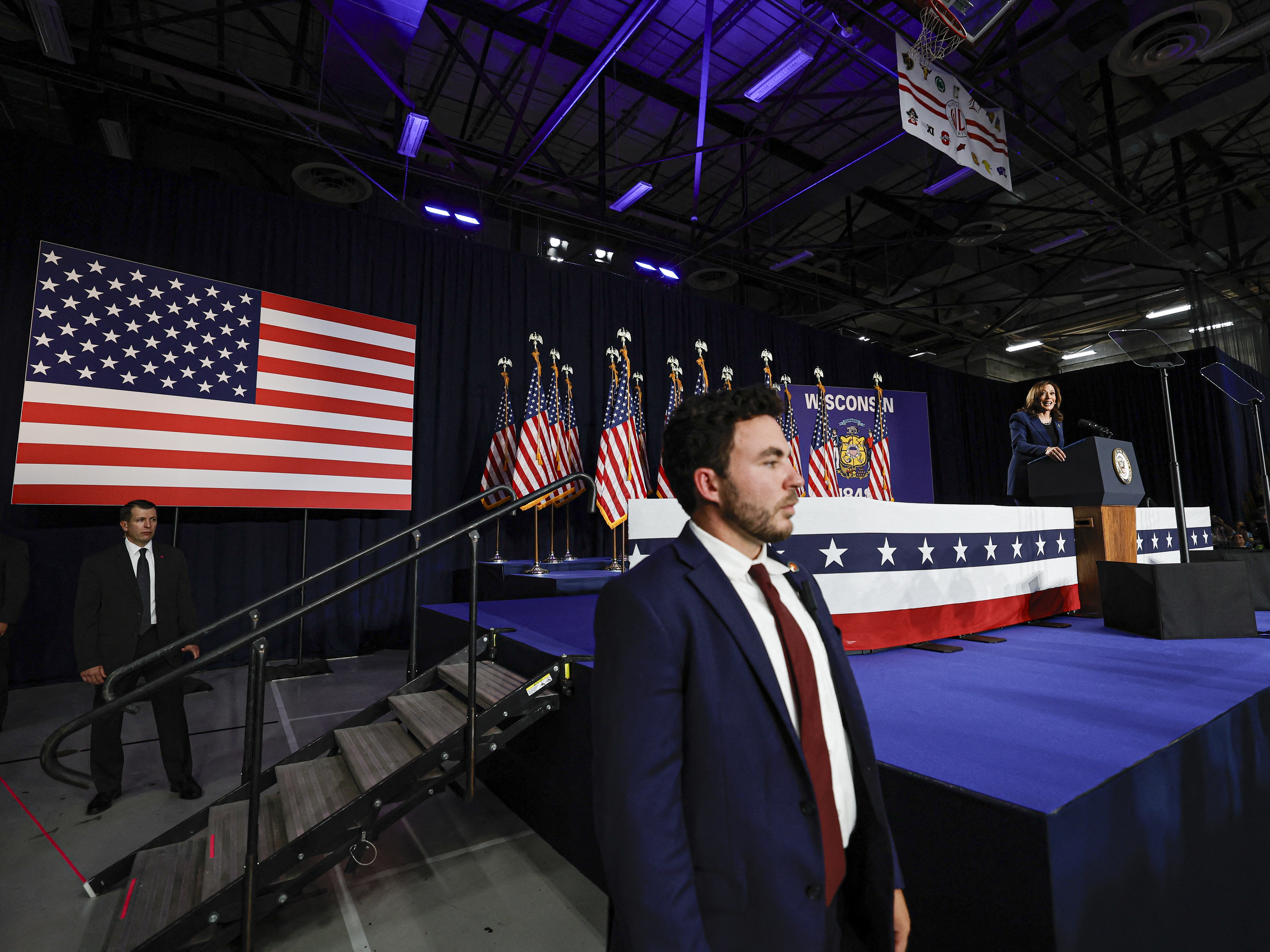 caption: Members of the U.S. Secret Service stand watch as Vice President and Democratic Presidential candidate Kamala Harris speaks during her first campaign rally in Milwaukee, Wisconsin, on July 23, 2024. The assassination attempt on former president Donald Trump, the abrupt withdrawal of President Joe Biden from the race have added even more fuel to an active landscape of conspiracy theories about the 2024 campaign.