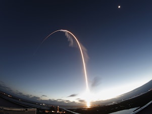 caption: A time exposure of the United Launch Alliance Atlas V rocket carrying the Boeing Starliner crew capsule on an Orbital Flight Test to the International Space Station lifts off from Space Launch Complex 41 at Cape Canaveral Air Force station, on Friday.