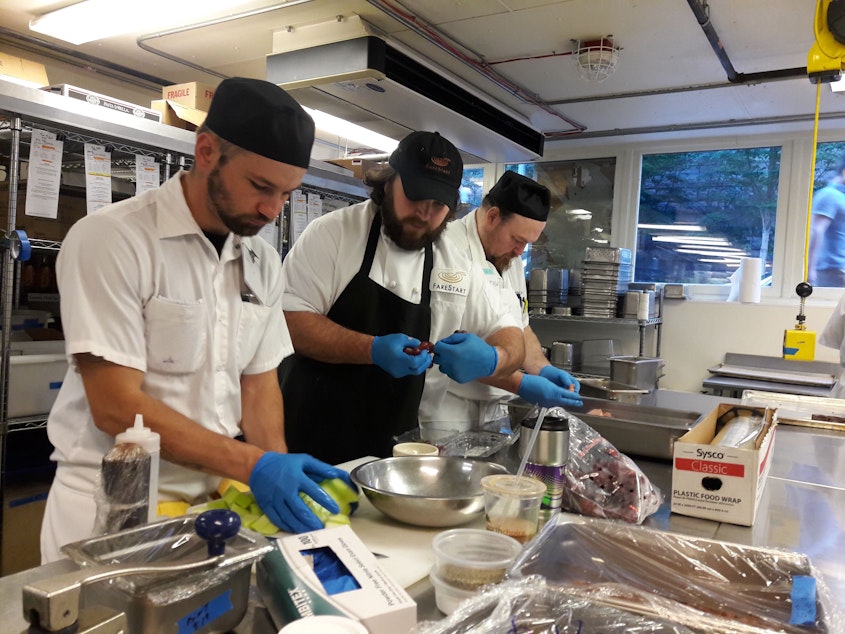 caption: FareStart, a Seattle non-profit that helps people transition from homelessness and addiction, had to retool its culinary training program during the pandemic.  In-person instruction, like this one, is now taught online. 