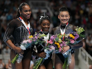 caption: Gymnasts Shilese Jones, Simone Biles and Leanne Wong pose after placing second, first and third in the all-around competition on the final day of women's competition at the 2023 U.S. Gymnastics Championships on Sunday in San Jose, Calif.