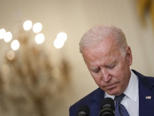 caption: President Biden bows his head in a moment of silence Thursday as he speaks about the situation in Afghanistan from the White House's East Room.