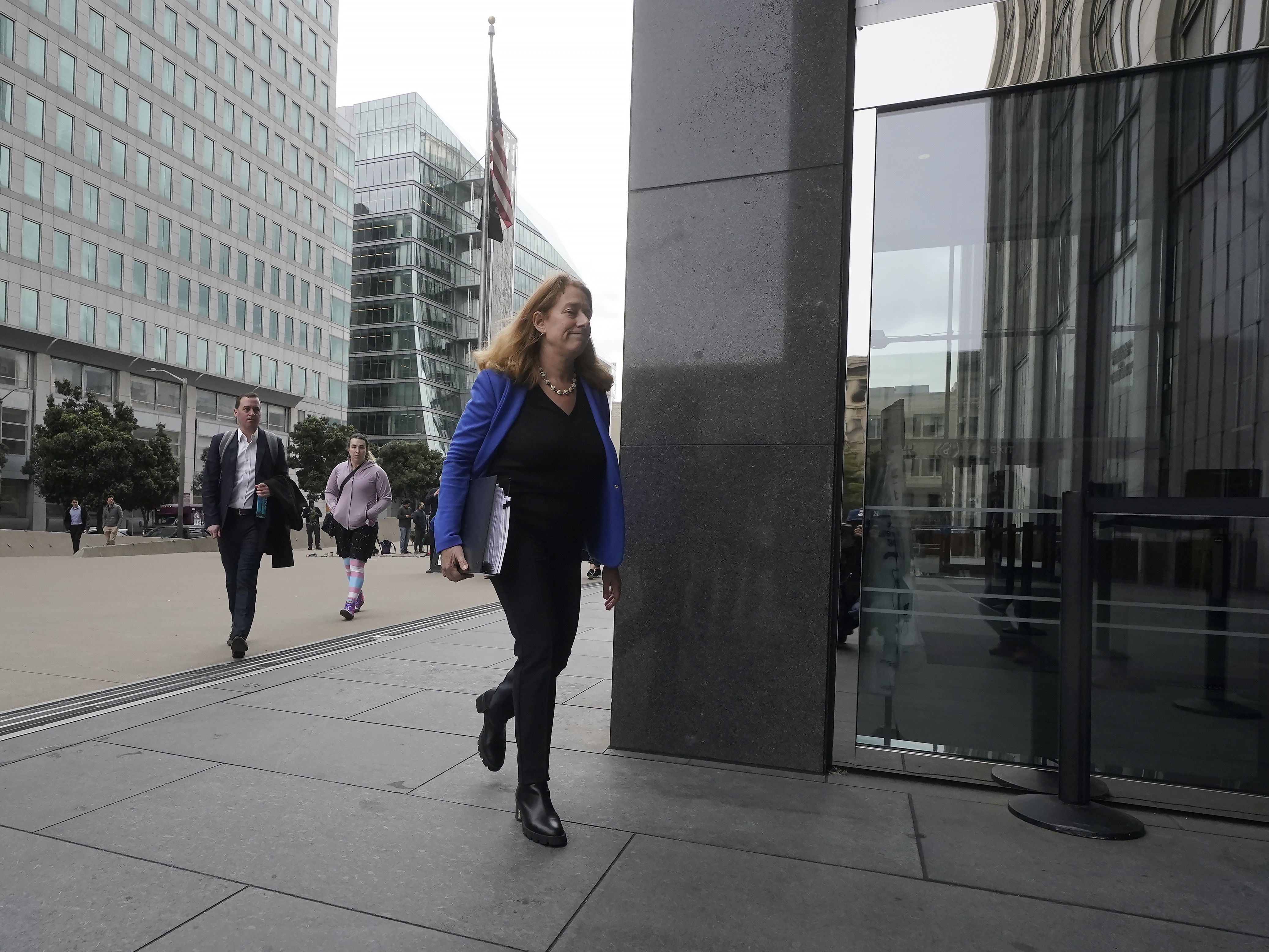 caption: Attorney Shannon Liss-Riordan walks toward an entrance to a federal courthouse in San Francisco in December 2022. She is representing thousands of former Twitter employees suing the company over severance and other issues.